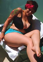 Big boobed babe Dors Feline tanning herself in a tiny bikini on the balcony