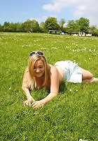 Holly strips off topless outside on a sunny day and lays on a field of daisy's